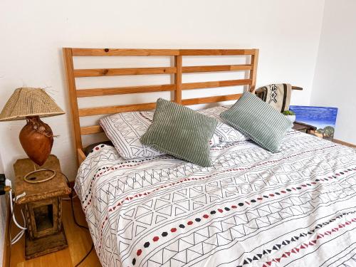 - une chambre avec un lit doté d'une tête de lit en bois et d'oreillers dans l'établissement L'Akwaba Fécamp, à Fécamp