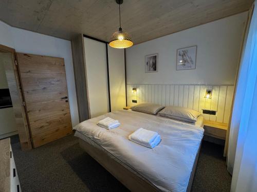 a bedroom with a bed with two towels on it at Apartmán I2 in Hrabušice