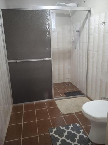 a bathroom with a shower with a toilet and a sink at Pousada Chale Pico da Bandeira in Alto Caparao
