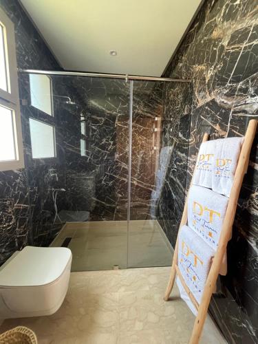 a bathroom with a shower with a toilet and a chair at Riad Tammam in Essaouira