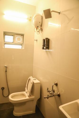 a bathroom with a toilet and a sink at F-3 Tulsi By The Peace in Chennai