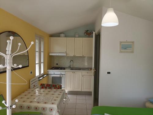 a kitchen with a table and a kitchen with yellow walls at [Piscina Privata] Tiger Home, Toscana in Capannori