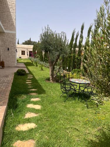 a garden with a table and chairs in the grass at Riad Tammam in Essaouira