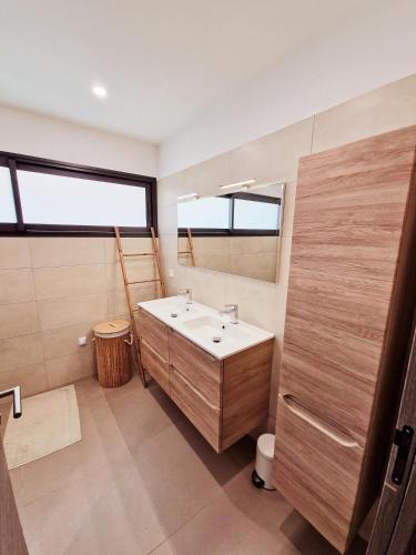 une salle de bain avec un lavabo et un miroir dans l'établissement Villa ALVALMAX, à Porto-Vecchio
