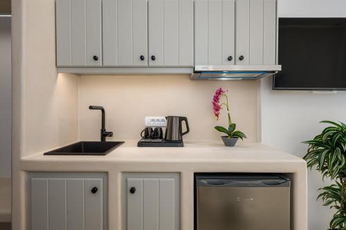 a kitchen with white cabinets and a sink at Galaria Serenity Suites in Vóthon