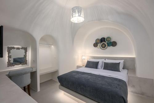 a white bedroom with a bed and a mirror at Galaria Serenity Suites in Vóthon