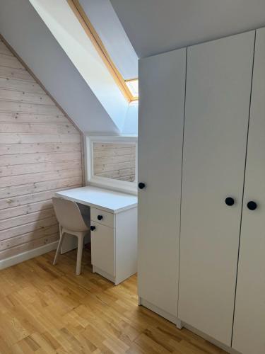 a attic office with a desk and a skylight at Jaśminowy Sad in Mikołajki
