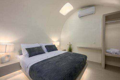 a white bedroom with a large bed with two pillows at Galaria Serenity Suites in Vóthon