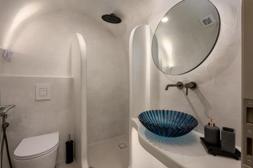 a bathroom with a sink and a toilet and a mirror at Galaria Serenity Suites in Vóthon