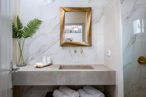 a bathroom with a sink and a mirror at Galaria Serenity Suites in Vóthon