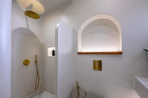 a white bathroom with a shower and a sink at Galaria Serenity Suites in Vóthon