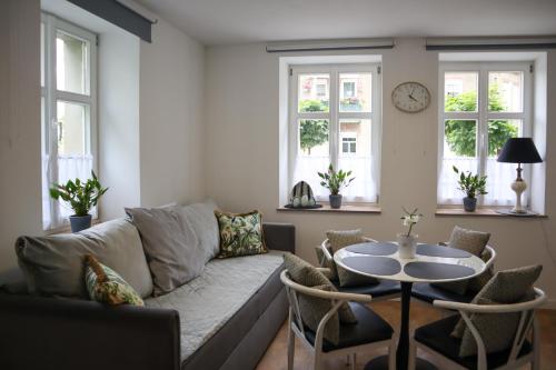 a living room with a couch and a table at Apartamenty Pocztowe in Opolno Zdrój