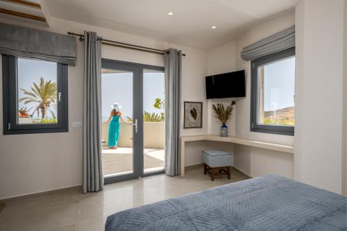 a woman is standing outside of a bedroom door at Galaria Serenity Suites in Vóthon