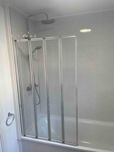 a shower with glass doors in a bathroom at Entire 2 bedroom flat Northumberland in Blythe