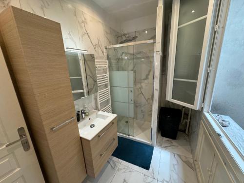 une salle de bain blanche avec une douche et un lavabo dans l'établissement Agora, à Nice