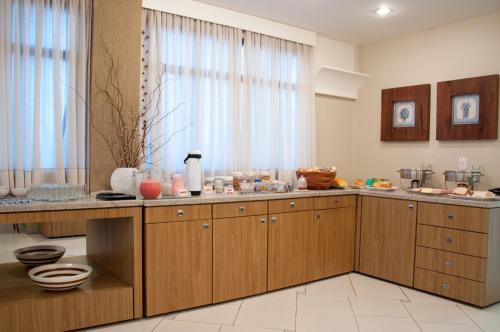 a kitchen with wooden cabinets and a large window at Hotel Linhatur in Linhares