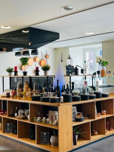 a room filled with shelves filled with pots and pans at Hôtel de Ville in Les Verrières