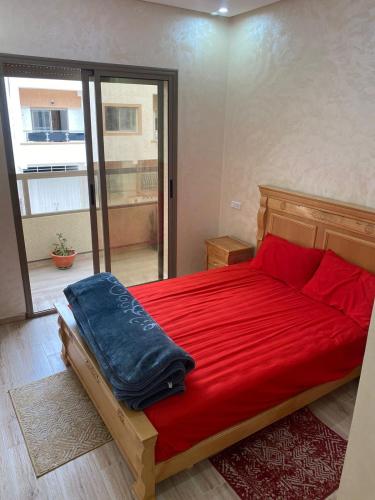 ein Schlafzimmer mit einem roten Bett mit einer roten Decke in der Unterkunft Chez Soad in Bouznika