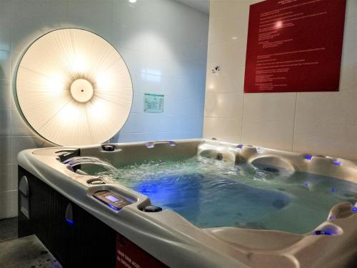 a jacuzzi tub in a room with a sign at Whalesbay Hotel Apartamentos in Capelas