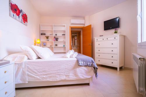 a bedroom with a bed with a dresser and a tv at Apartamento CyM in Ronda