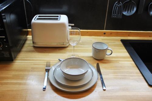 a table with a plate and a glass of wine at La place Zen - Free Wifi - City Center in Nîmes