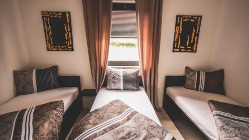 a small room with two beds and a window at Villa Eden Bihać in Bihać