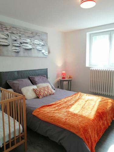 - une chambre avec un lit recouvert d'une couverture orange dans l'établissement Chez pépé, à Clohars-Carnoët