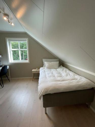 a bed in a room with an attic at House with 5 bedrooms, 2 bathrooms, available for ONSS in Stavanger
