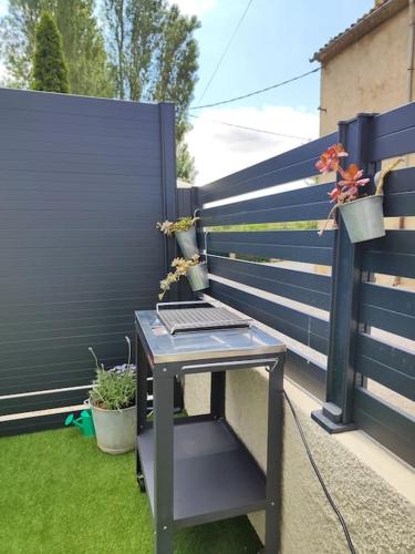 a bench with a laptop sitting on it next to a fence at Gîte Le Sallèles in Sallèles-dʼAude