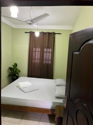a bedroom with a bed and a ceiling fan at Star Eyes Hostel in Weligama