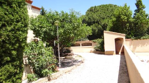 a garden with trees and a building with a door at Résidence L'Orangeraie-2-Claira 66530 in Claira