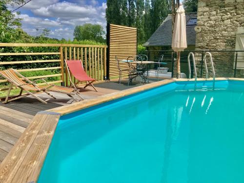 - une piscine sur une terrasse avec une table et des chaises dans l'établissement MAISON Éclusière piscine jacuzzi fauteuil massant, à Carhaix-Plouguer