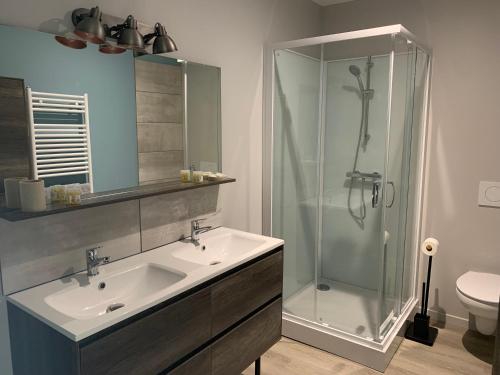 une salle de bain avec un lavabo et une douche dans l'établissement COTTAGES LA CHENERIE, à Ancteville