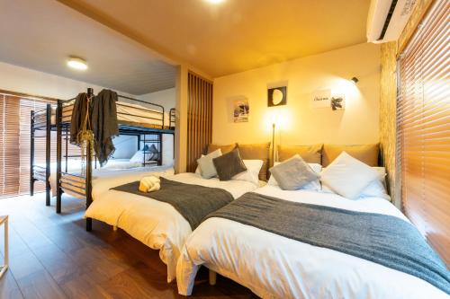 a bedroom with two beds and a bunk bed at Granz Morinomiya in Osaka