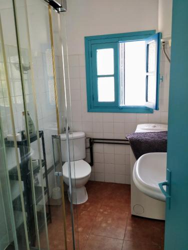 Un baño con inodoro, lavabo y ventana. en Vintage MAYLU, en Algarrobo