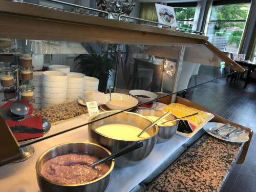 a buffet with bowls of food on a counter at Hotel Prinzenpalais Bad Doberan in Bad Doberan