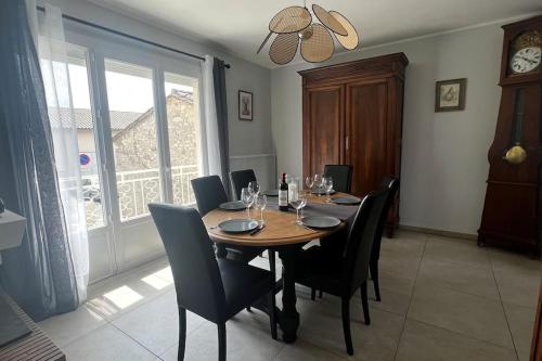 une salle à manger avec une table et des chaises en bois dans l'établissement Jolie maison individuelle de Village avec Jardin, à Villeréal
