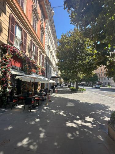 an empty street with tables and umbrellas next to a building at Luxury Apartment Via Veneto in Rome