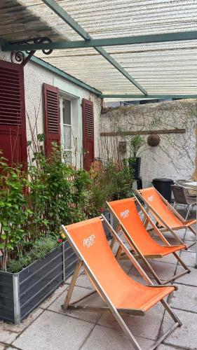 three orange lawn chairs sitting on a patio at Hôtel Continental in Évian-les-Bains