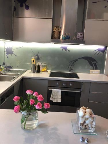 a kitchen with flowers and a vase of pink flowers at Pines House in Draç