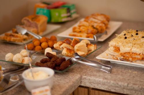 a table topped with different types of pastries and desserts at Hotel Linhatur in Linhares