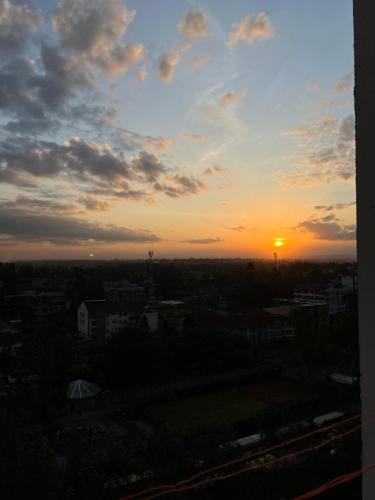 a sunset over a city with the sun in the sky at The Esme near the Loft Thika Rd in Nairobi