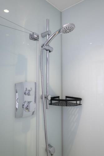 a shower with a shower head in a bathroom at Upper Rock Brighton Apartments in Brighton & Hove