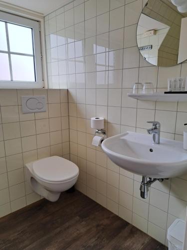 a bathroom with a toilet and a sink at Hotel Het Gouden Boltje in De Koog