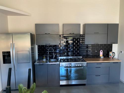 Il comprend une cuisine équipée d'une cuisinière en acier inoxydable et d'un réfrigérateur. dans l'établissement Type t3 Lancon de Provence, à Lançon-Provence