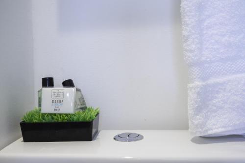 a white counter with a bottle of soap and grass at Upper Rock Brighton Apartments in Brighton & Hove