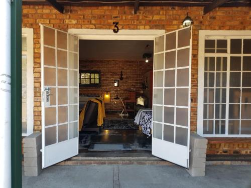 an open door into a room with a brick wall at Havana Nights in Graskop