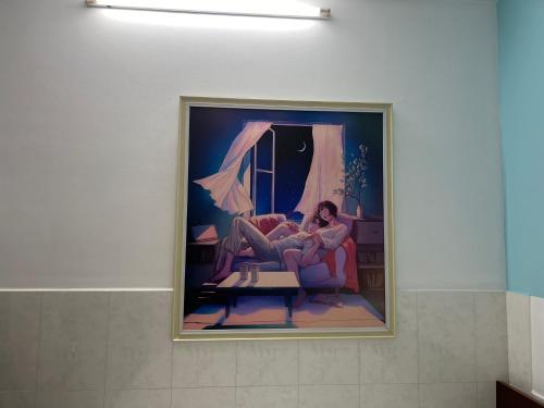 a painting of a woman sitting on a couch at Bin Hom Motel in Bien Hoa