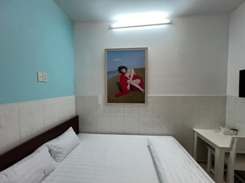 a bedroom with a bed and a picture of a couple at Bin Hom Motel in Bien Hoa