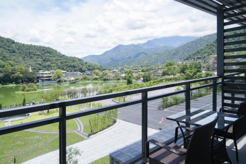 a balcony with a view of a river and mountains at Izumi Boutique Hotel in Puli